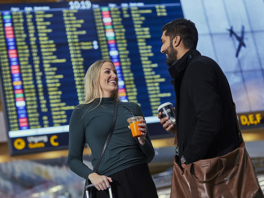 Mennesker foran en flyinformasjon skjerm