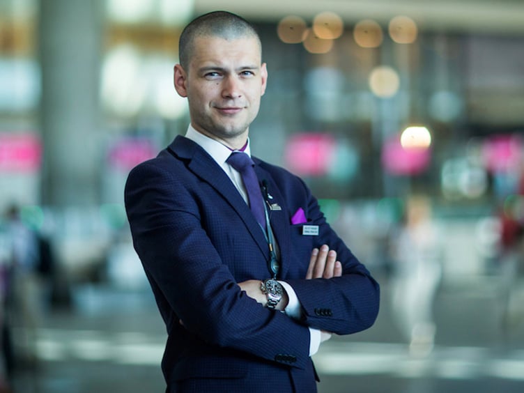 Person i formell dress på en travel flyplass, lyssettingen gir en profesjonell atmosfære.