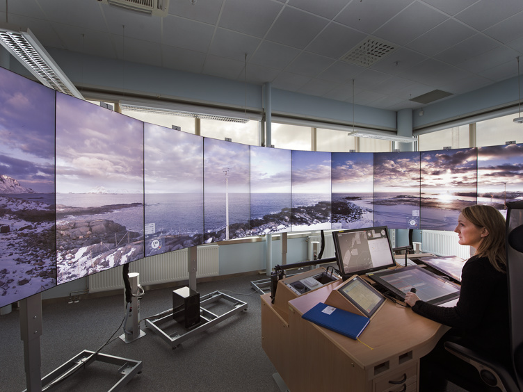 En AFIS-fullmektigs sitter på vakt ved RVT skjermene på Bodø lufthavn.